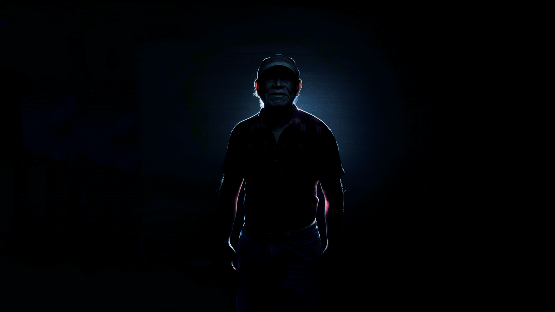 Original: Ambiente completamente escuro,  apenas com uma luz revelando a silhueta de um homem.